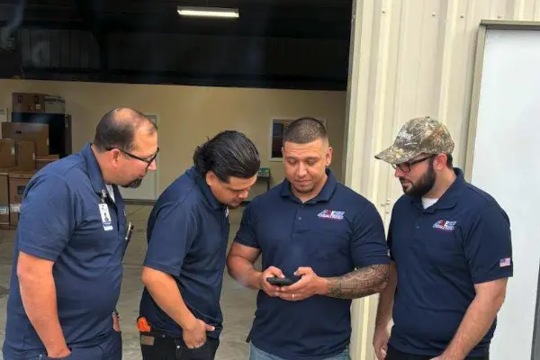 Four ACE crew members in navy polos in their own warehouse